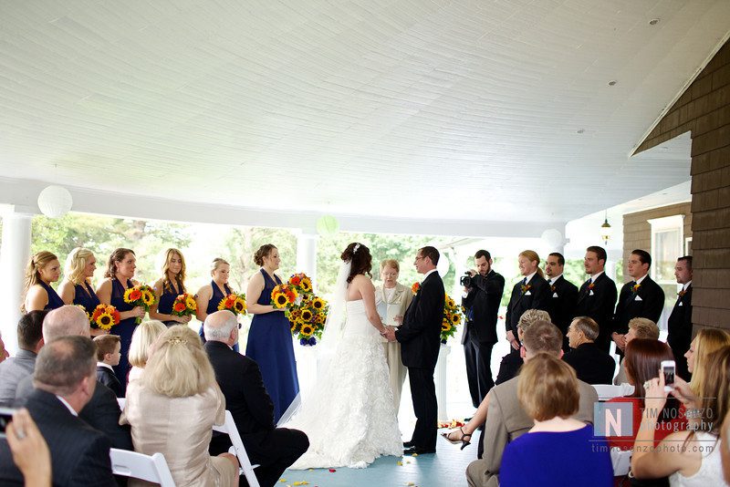 bride and groom exchanging vows in front of guests on veranda