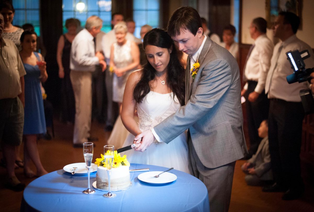 couple holding the knofe to cut the cake