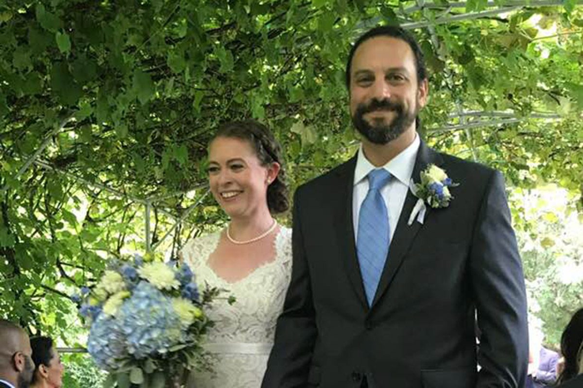 outdoor-wedding-couple-walking-down-grape-arbor-aisle-after-july-ceremony