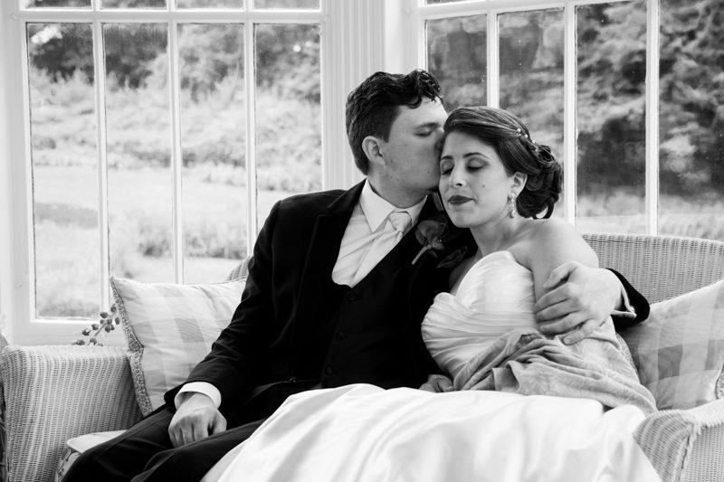 Robert holding Rachel on the wicker couch in the lilly pond porch