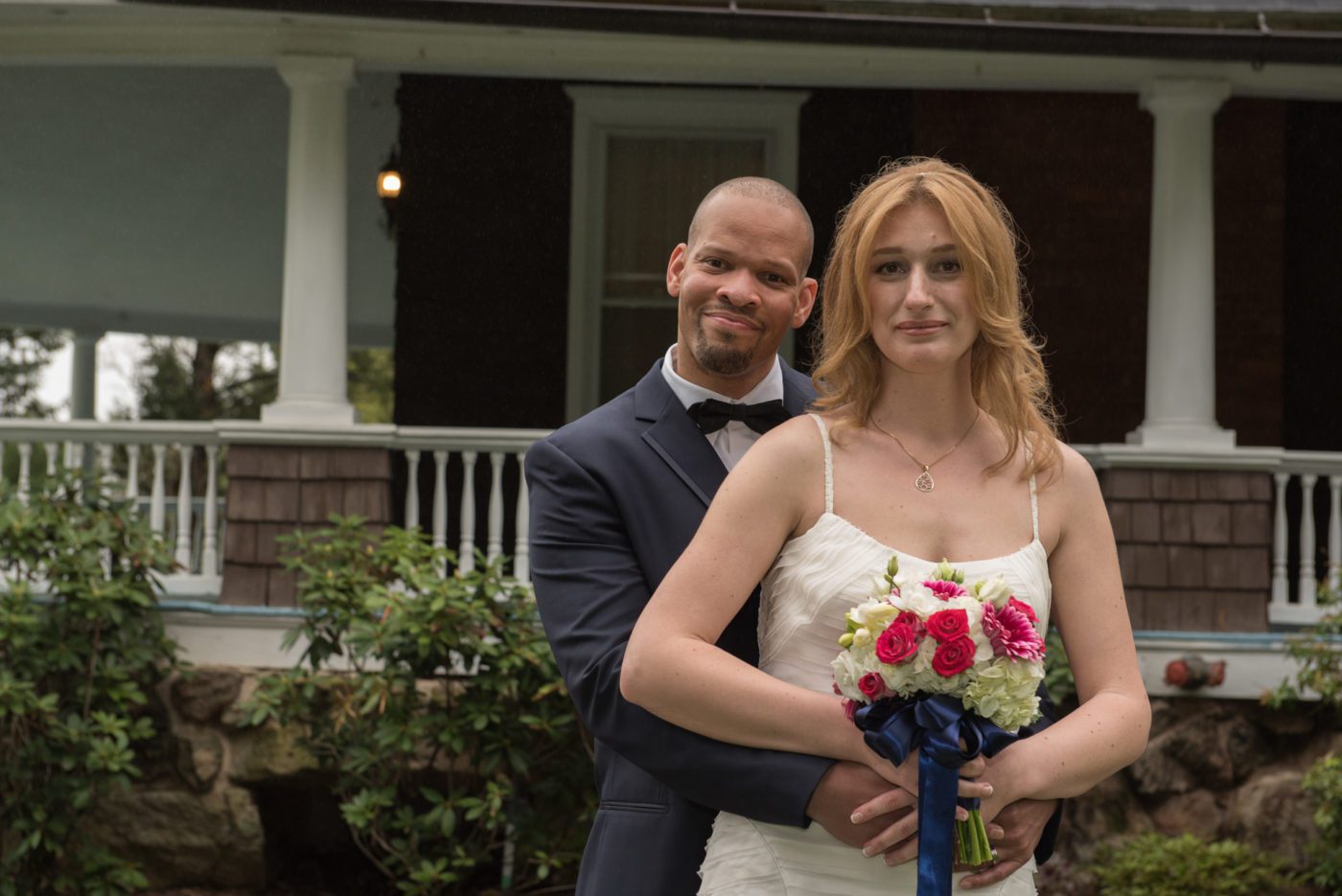 bride and groom standing close in front of mansion