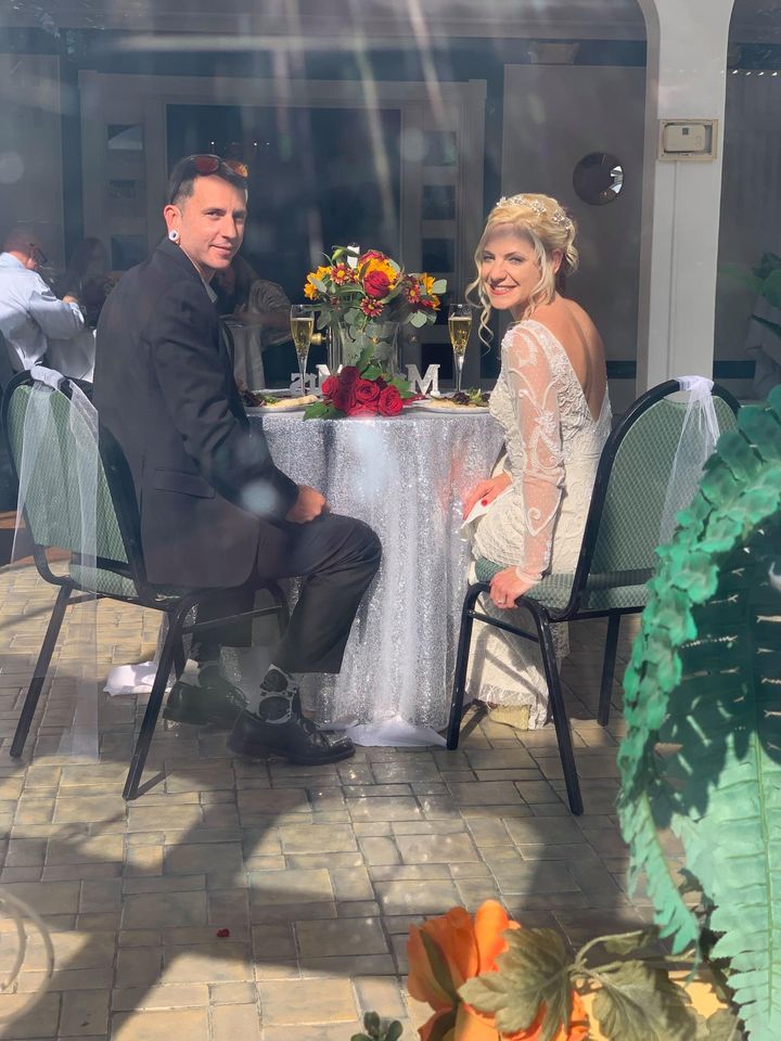 couple seen througj window at sweetheart table